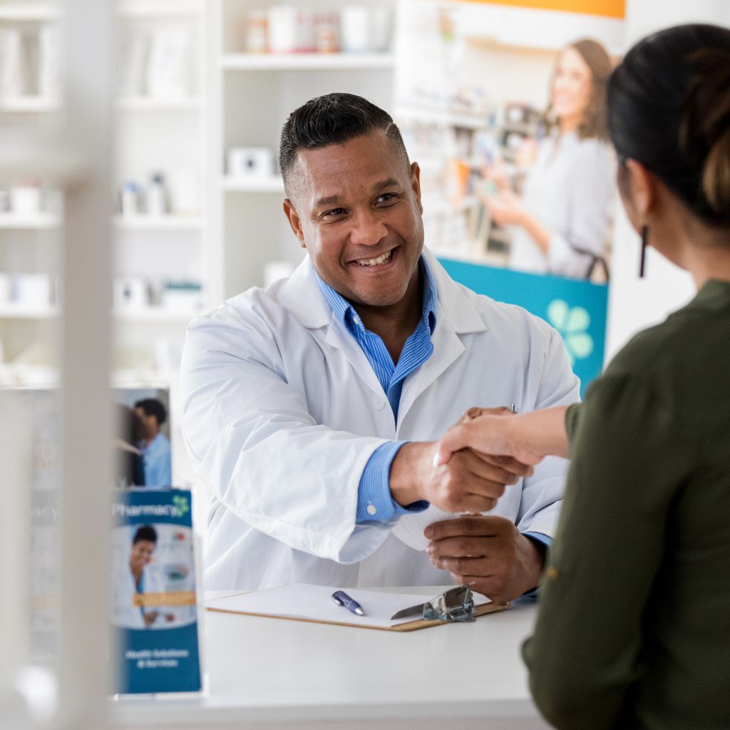 male pharmacist helping female customer