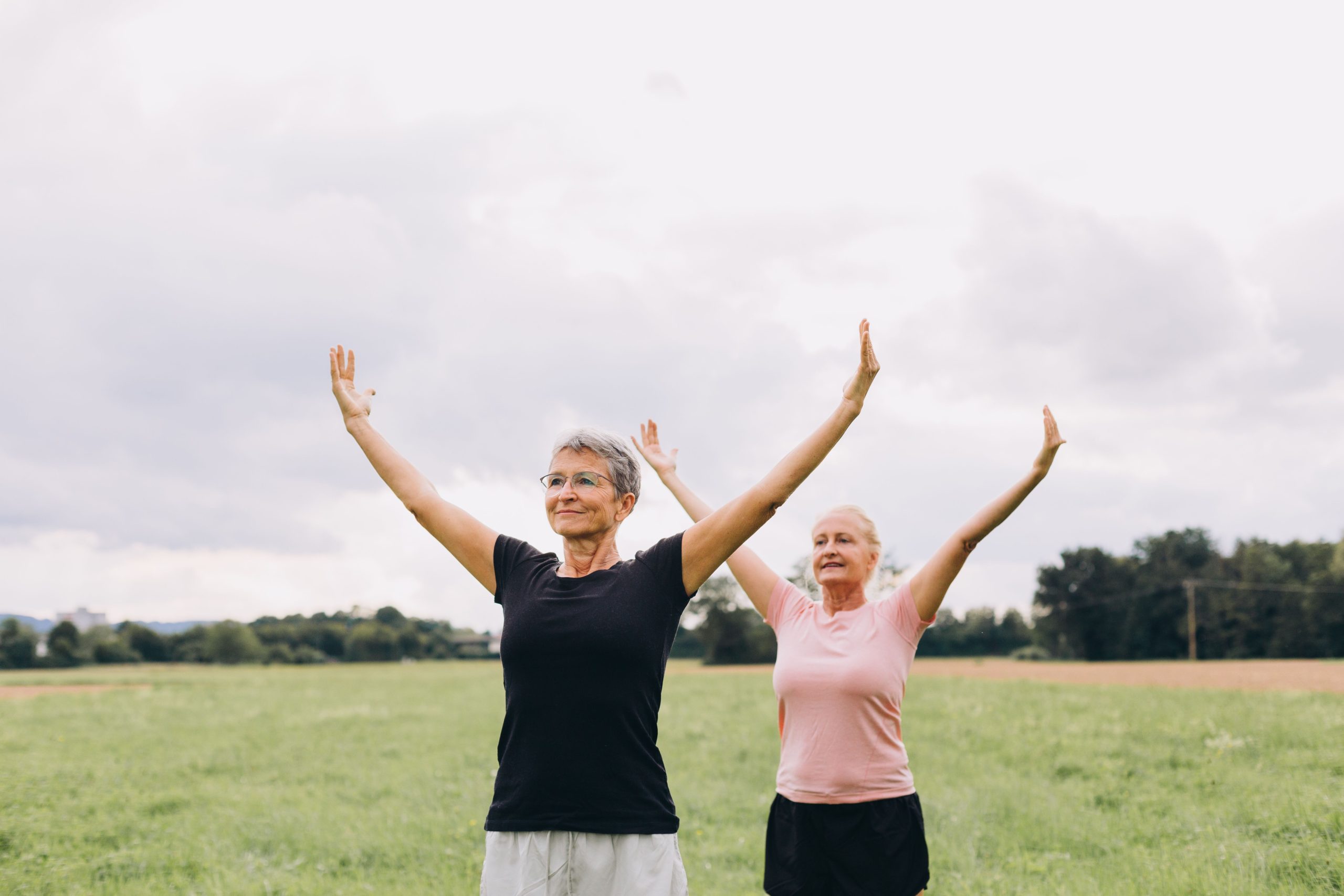 two elderly women performing a yoga pose