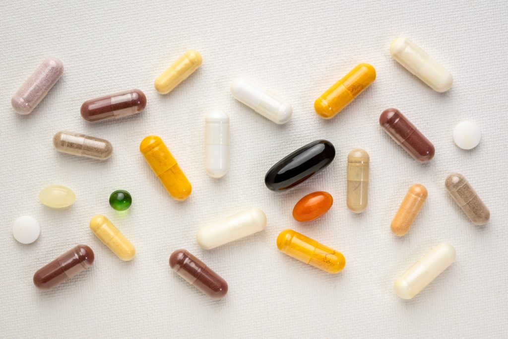 vitamins and supplements scattered across canva background